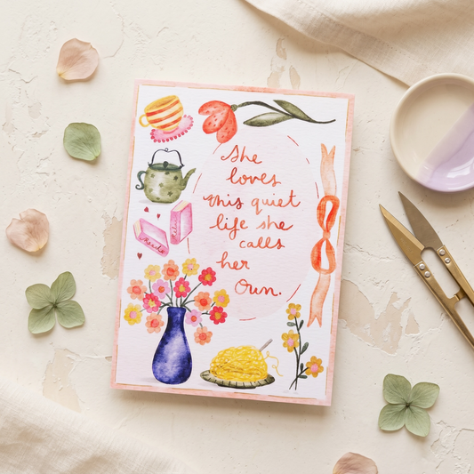 A square watercolor art print with a pink border, featuring a quote by Eleanor Roosevelt and colorful illustrations of tea-time objects and flowers, styled in a flat-lay on a textured cream surface with scattered petals, a small dish, and gold-toned cutlery.